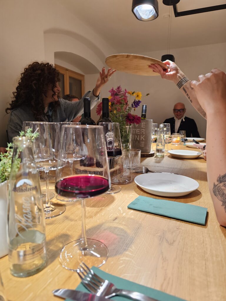 People sitting around a table sharing pizza and drinking wine