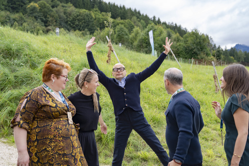 4 people standing, with Marcus doing a star jump in the background