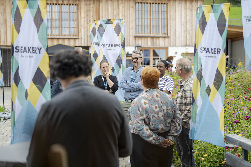 Standing outside the lodge surrounded by people and banners