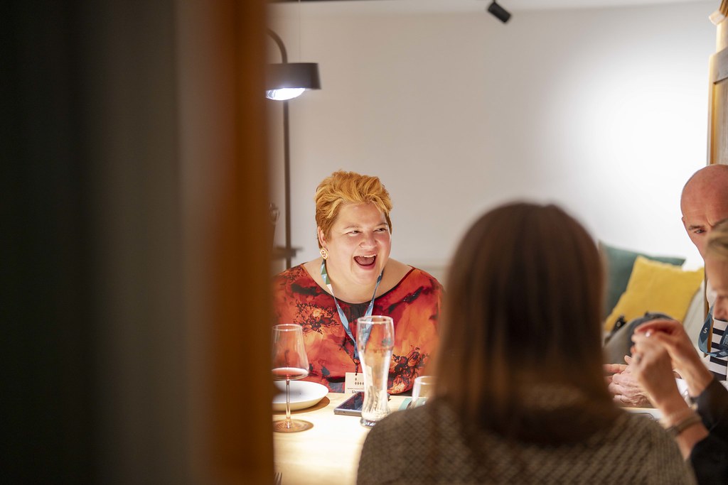 Lisa brightly lit laughing at a table