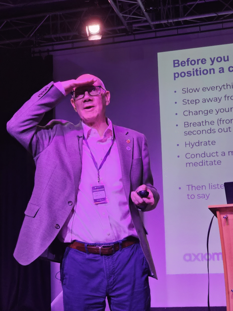 Man shielding his eyes as he looks up above the camera